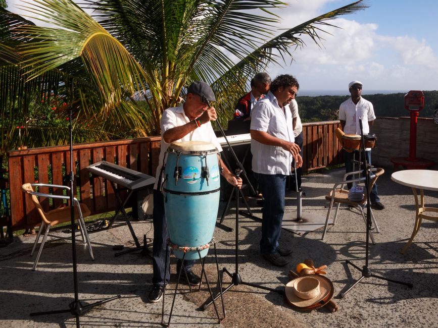A group of musicians performing live outdoors featuring congas, keyboards, and percussion instruments. - Best Places to Hear Live Reggae and Calypso Music in Barbados