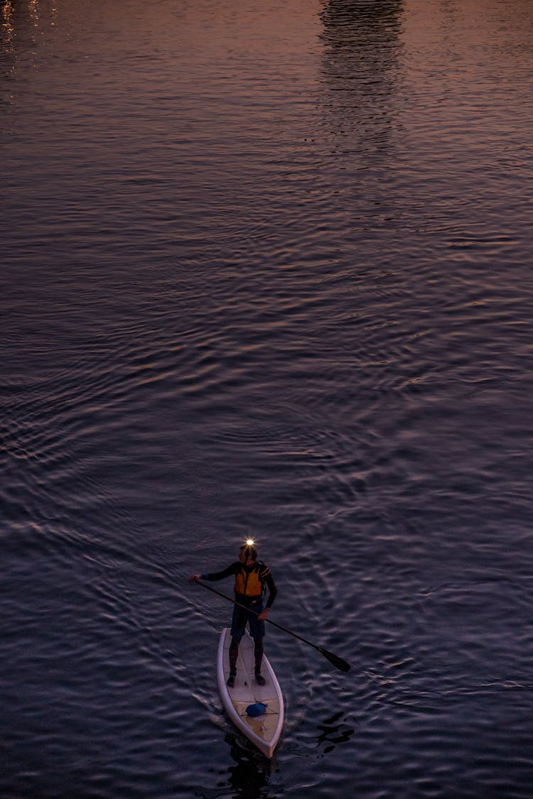 Man Using A Paddle Board In A Body Of Water