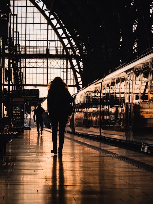 Back View of a Person Walking Inside a Train Station