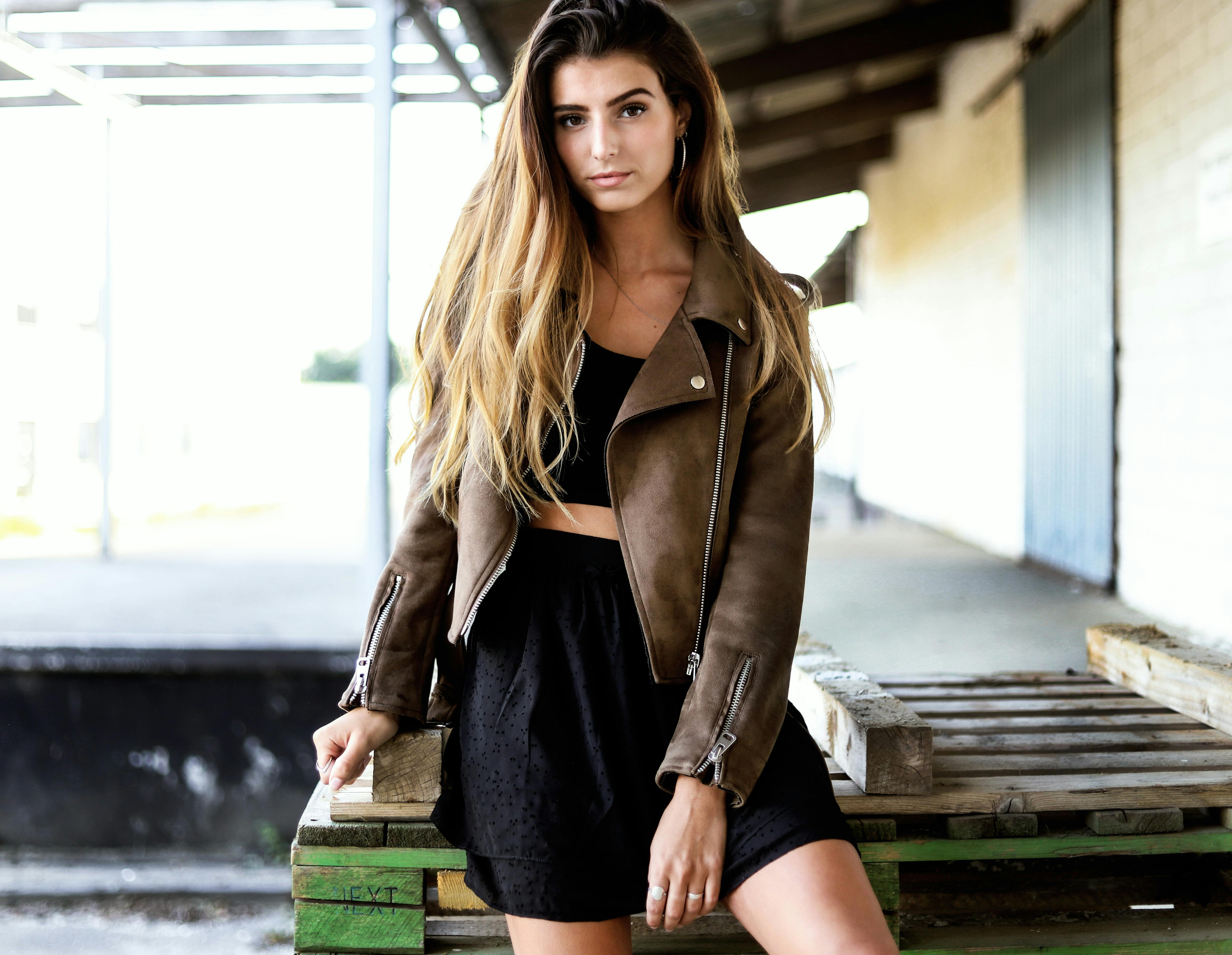 A fashion-forward woman poses confidently in Silkeborg wearing a leather jacket.