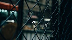 链条栅栏以散景灯为背景的特写，营造出喜怒无常的氛围