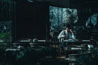 一个男人独自在灯光昏暗的咖啡馆里读书，显得十分宁静