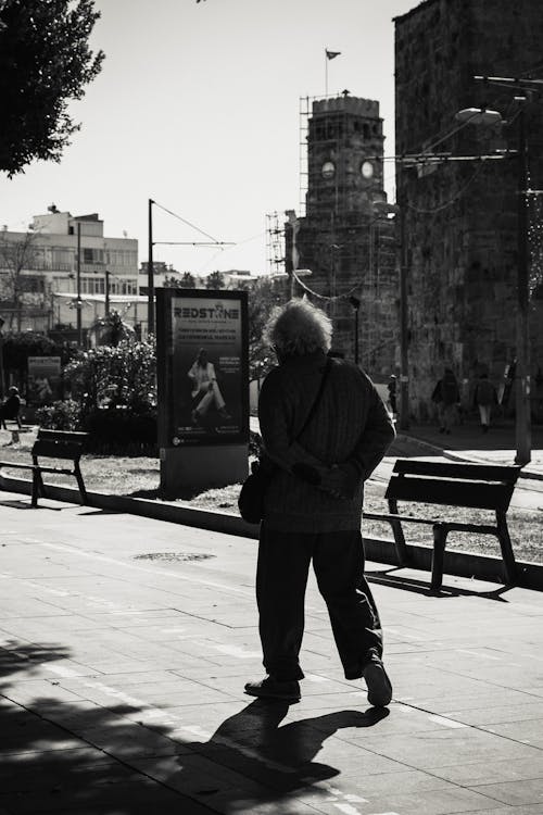 Elderly Man Walking in Grayscale Photography