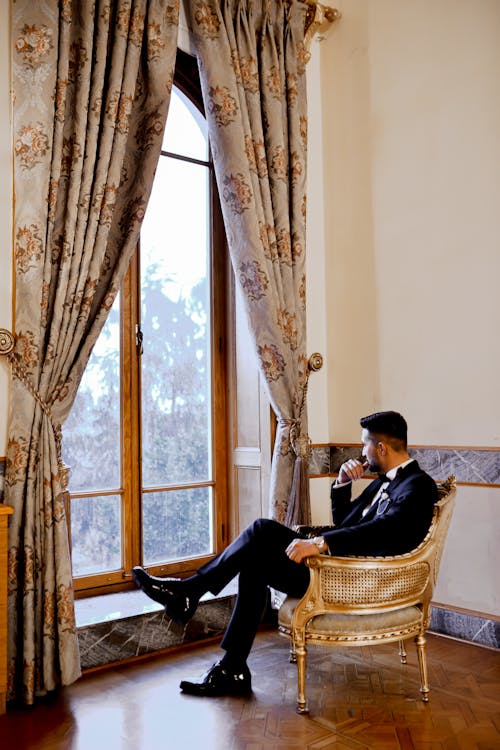A Man in a Suit Looking Out the Window 