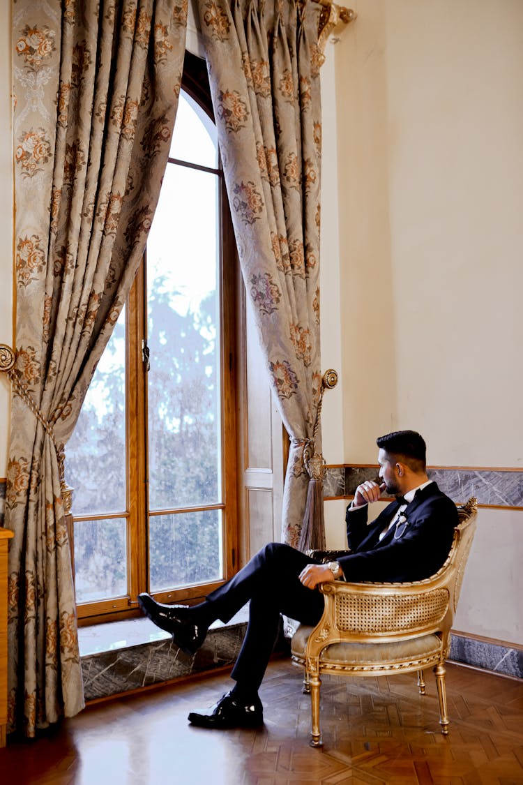 A Man In A Suit Looking Out The Window 