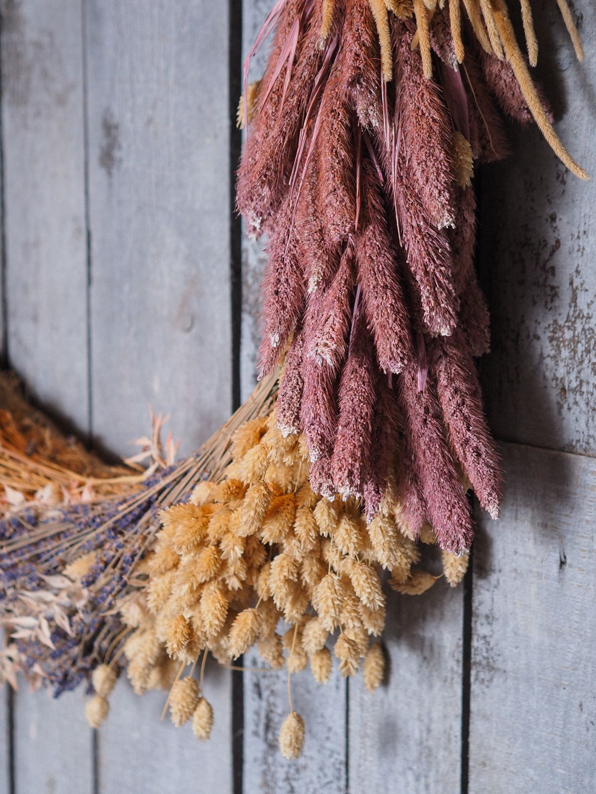Close-up of a rustic dried floral wreath on a wooden wall
