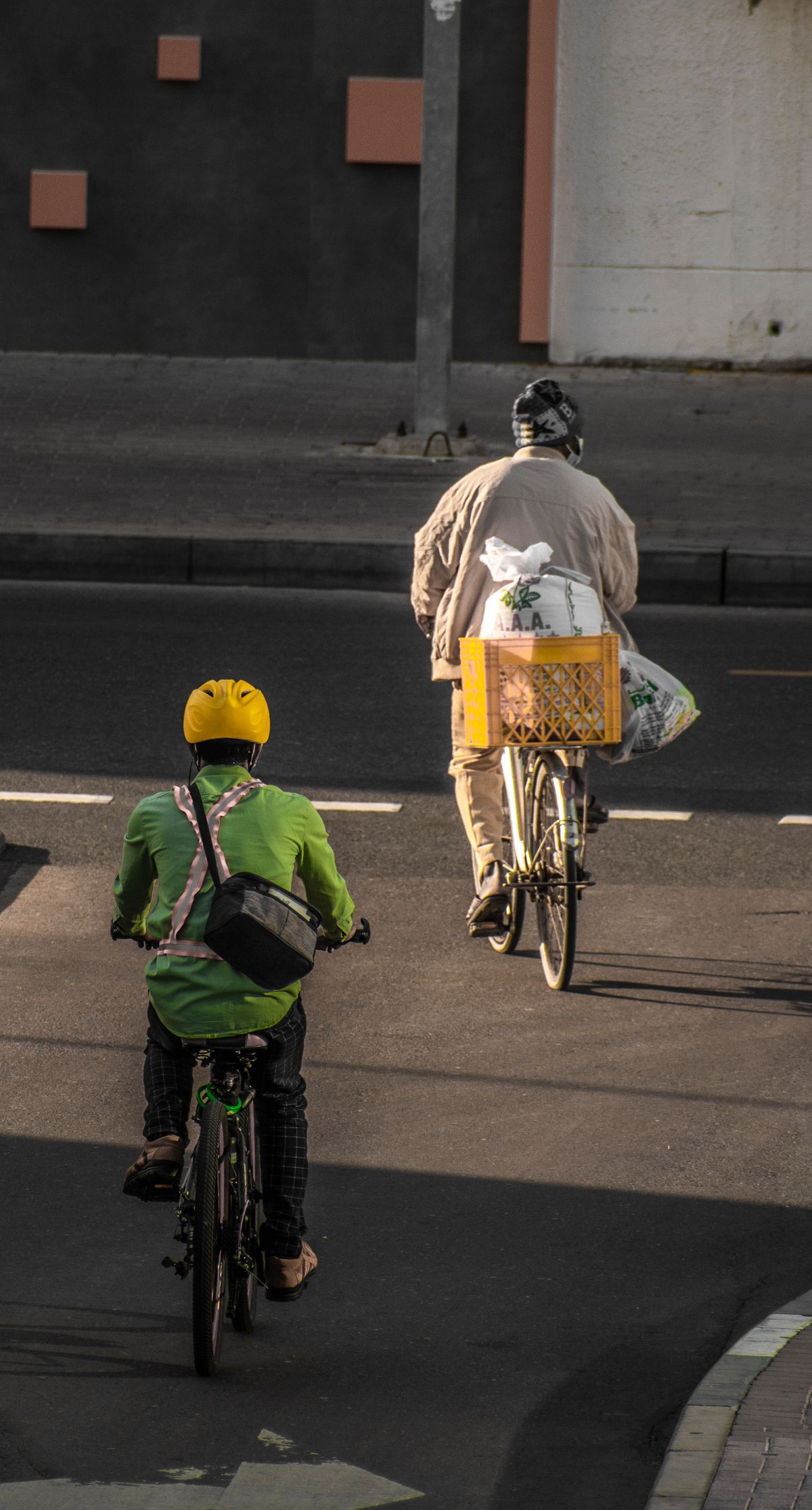 Helmeted cyclists riding together through a modern city