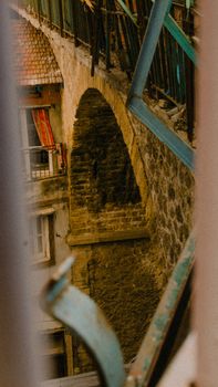 Charming street view of a historic arch bridge with urban elements in a warm, nostalgic tone.
