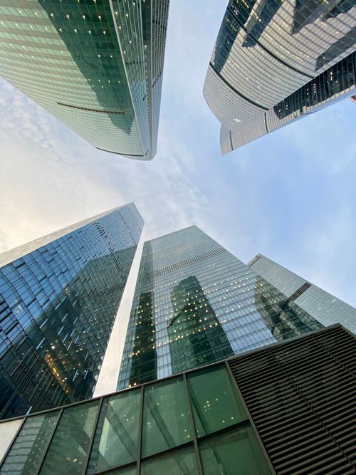 Free Low angle view of modern skyscrapers with glass facades reflecting the clear sky. Stock Photo