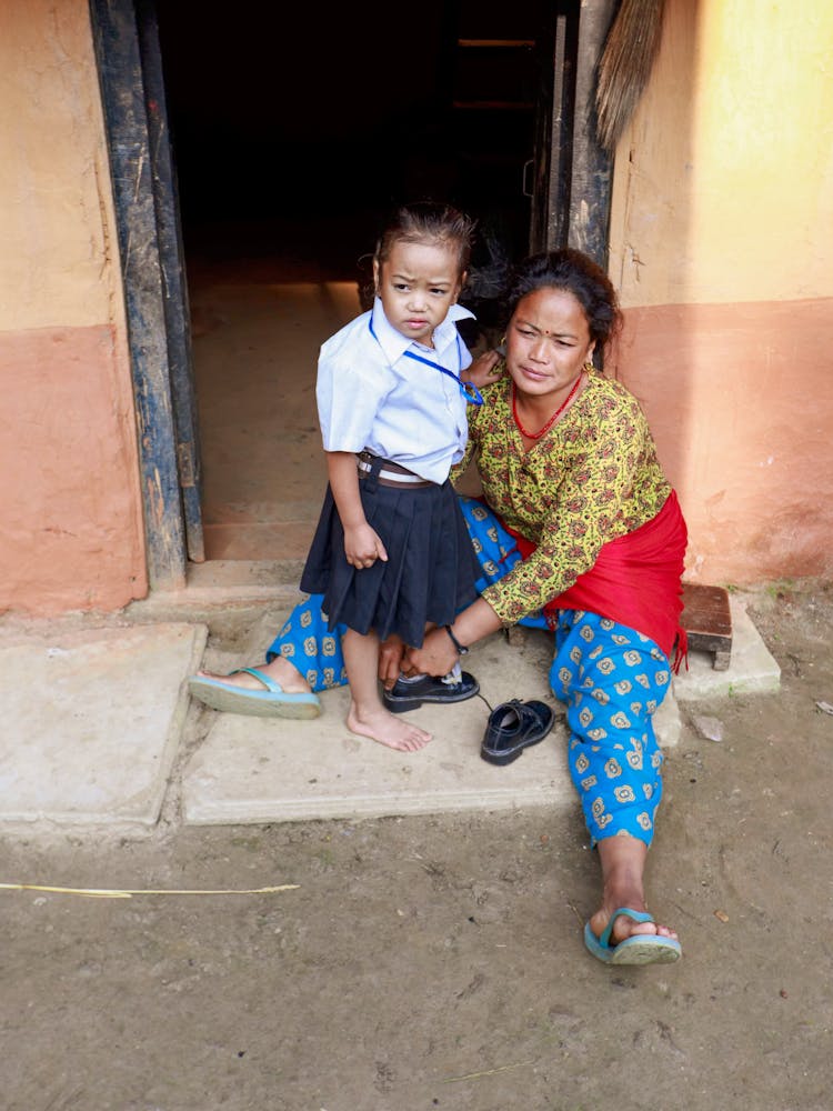 Young Girl In Student Uniform Standing Beside Her Mother 