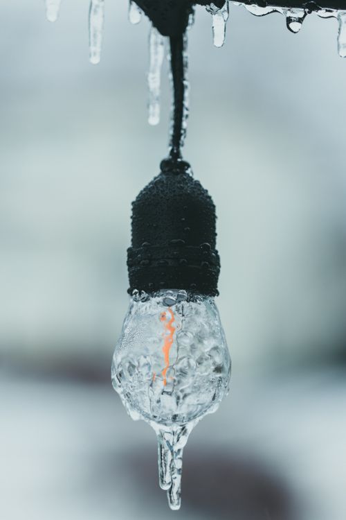 Free Close-up of a light bulb covered in ice, showcasing winter chill and texture. Stock Photo