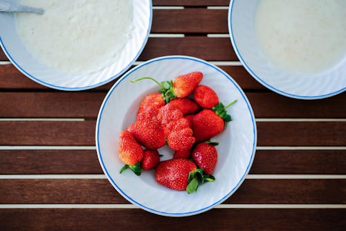 A Plate Filled with Delicious Strawberries on a Wooden Table
