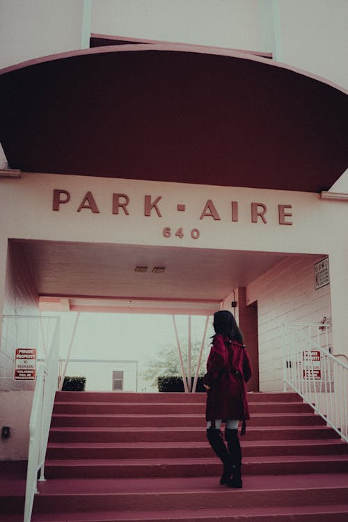 A Person in Red Coat Walking Up the Steps of Park-Aire Apartments