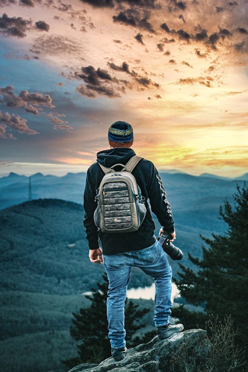 Backview of a Backpacker standing on a Cliff 