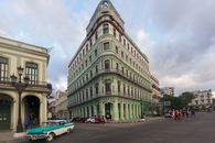 Stunning street view of vintage cars and classic architecture in Havana, Cuba.