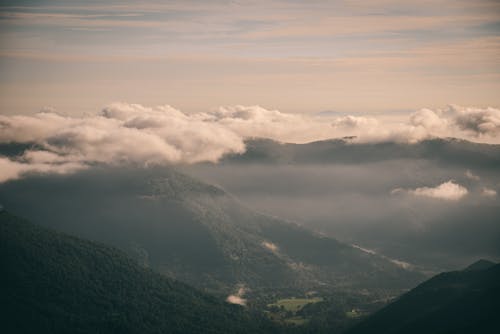 Aerial View of Mountains Under Cloudy Sky