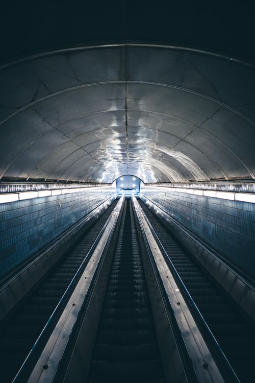 Free A vertically shot escalator in a subway station tunnel, showcasing symmetry and architecture. Stock Photo