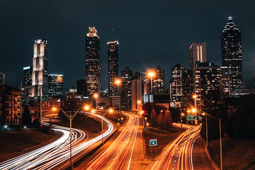 Dynamic night cityscape featuring vibrant skyscraper lights and dynamic highway light trails.