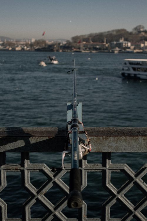 Free Fishing rod on Galata Bridge with scenic view of Bosphorus in Istanbul, ideal for travel and leisure themes. Stock Photo