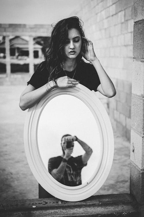 Woman Holding Mirror with Man Reflection