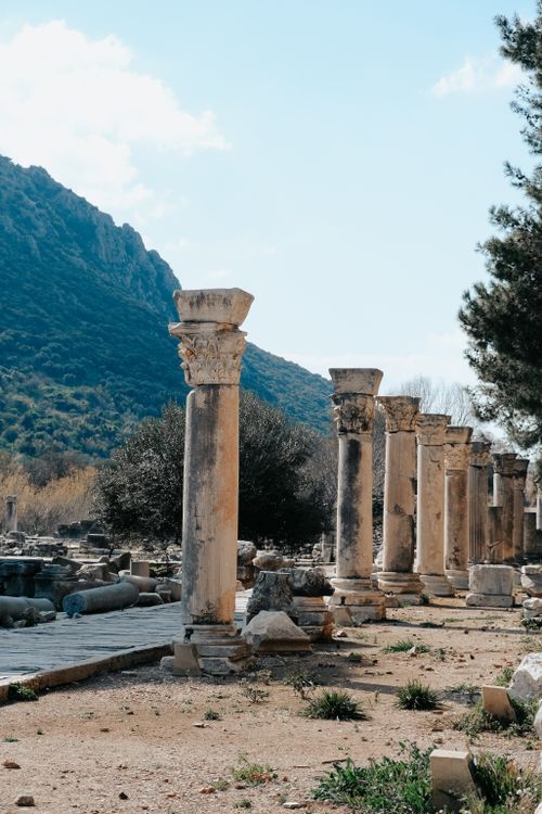 Free Explore the ancient stone columns set in picturesque ruins against a mountainous backdrop. Stock Photo