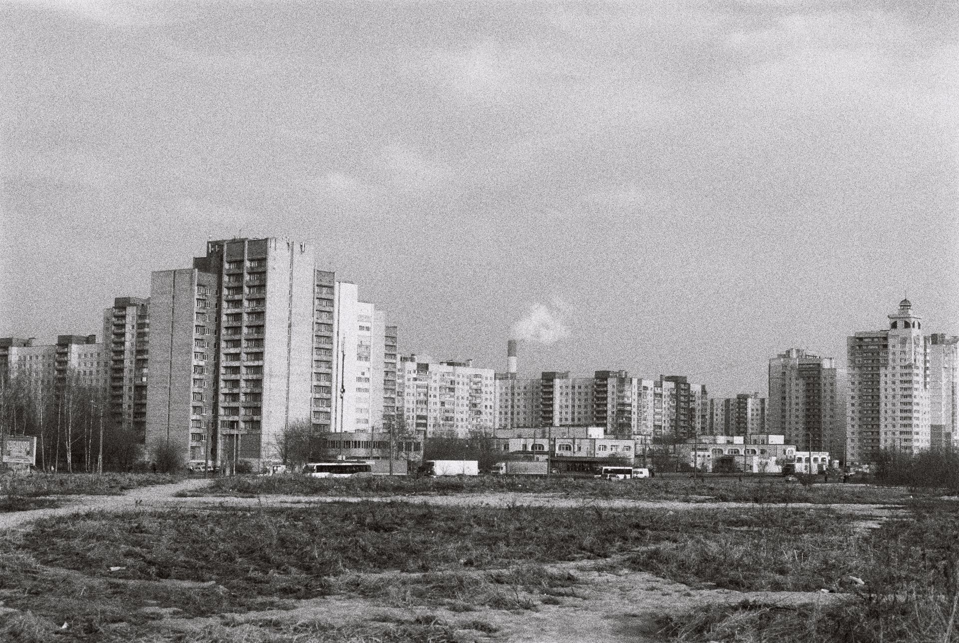 Grayscale cityscape featuring high-rise residential buildings with a barren foreground, showcasing urban architecture.