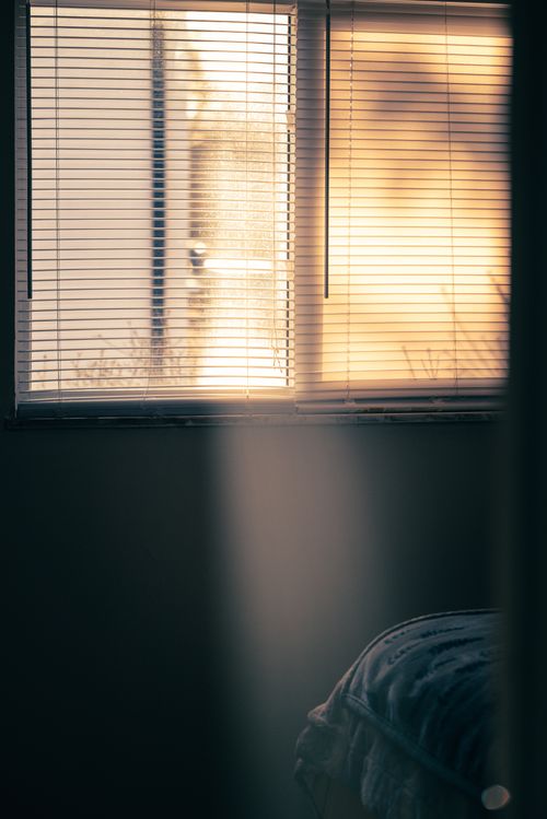 Free Soft morning or evening light casting shadows through window blinds in a cozy bedroom. Stock Photo