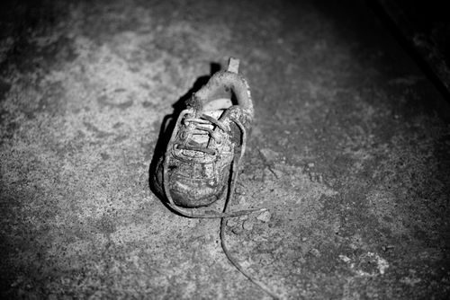 Free Grayscale image of a single old shoe on a concrete floor, highlighting textures. Stock Photo
