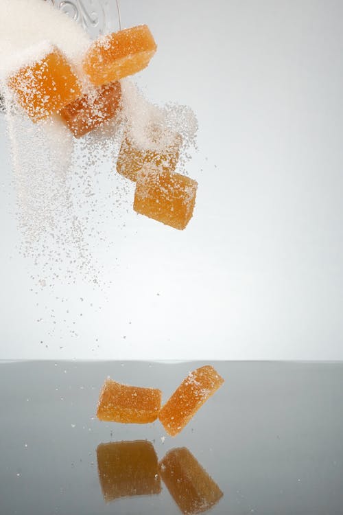 Free Pouring of Sugar and Orange Sweets  Stock Photo