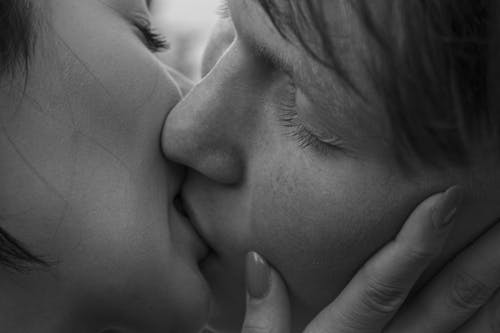 Grayscale Photo of Couple kissing each other 