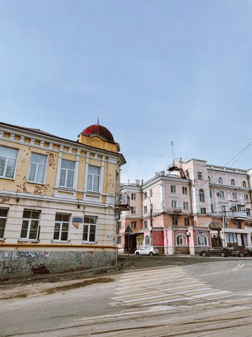 Free A captivating view of aged urban architecture on a quiet street corner with a blue sky. Stock Photo