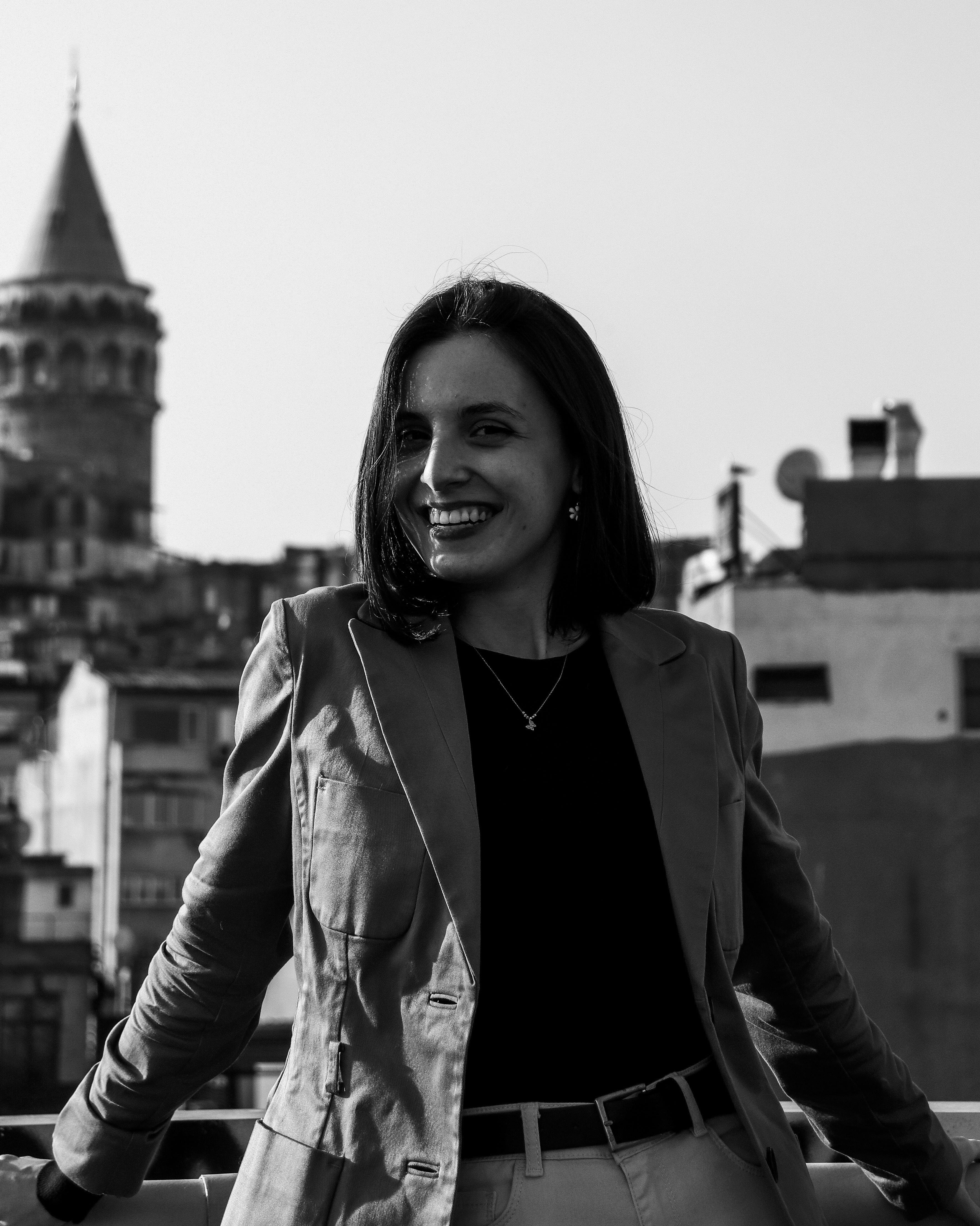 Stylish woman posing with the iconic Galata Tower in the background, in black and white.