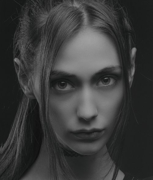 Free Close-up black and white portrait of a young woman with intense gaze. Stock Photo