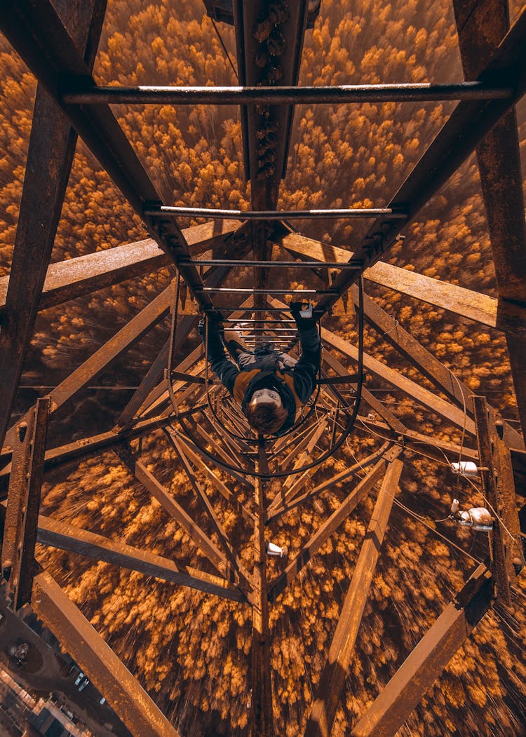 Person Climbing A Metal Tower