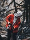 A Person in Gray Hoodie Under a Red Jacket Holding a Camera