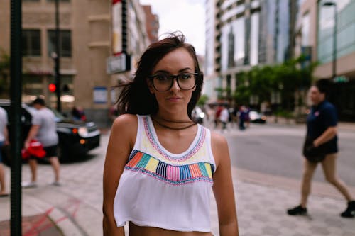 Woman in White and Pink Tank Top Standing on Sidewalk