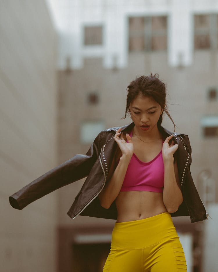 Girl Wearing Pink Top Uncovering Belly Yellow Pants And Black Leather Jacket 