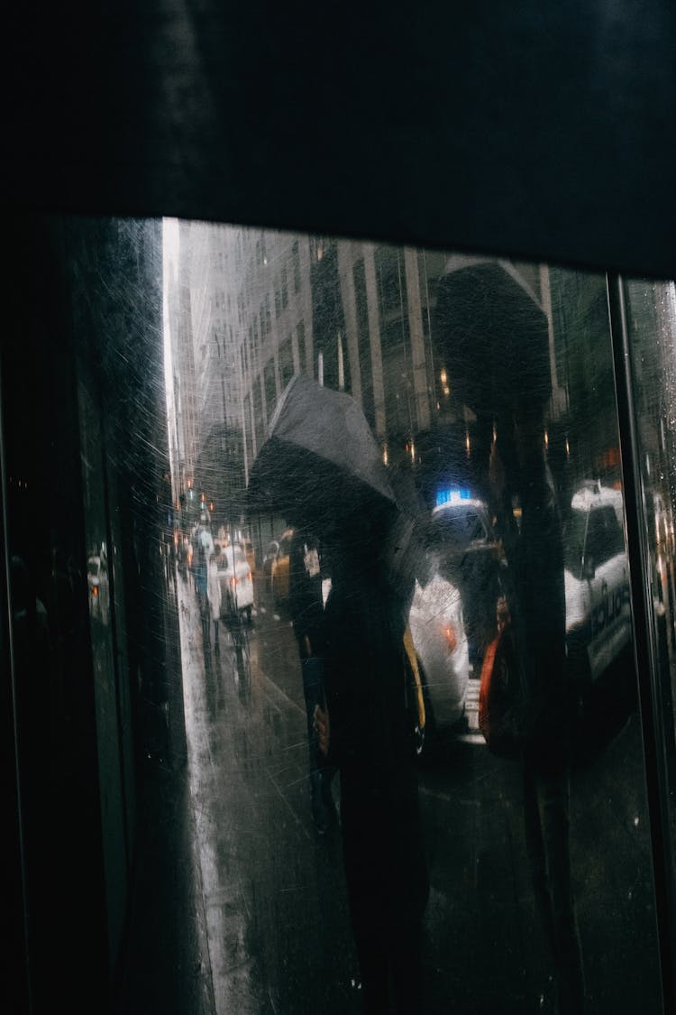 People On Street In Rain Behind Window