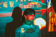 Woman Standing in Colourful Illumination from Projector