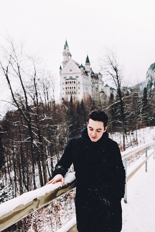 Smiling Man Touching a Railing in Snow