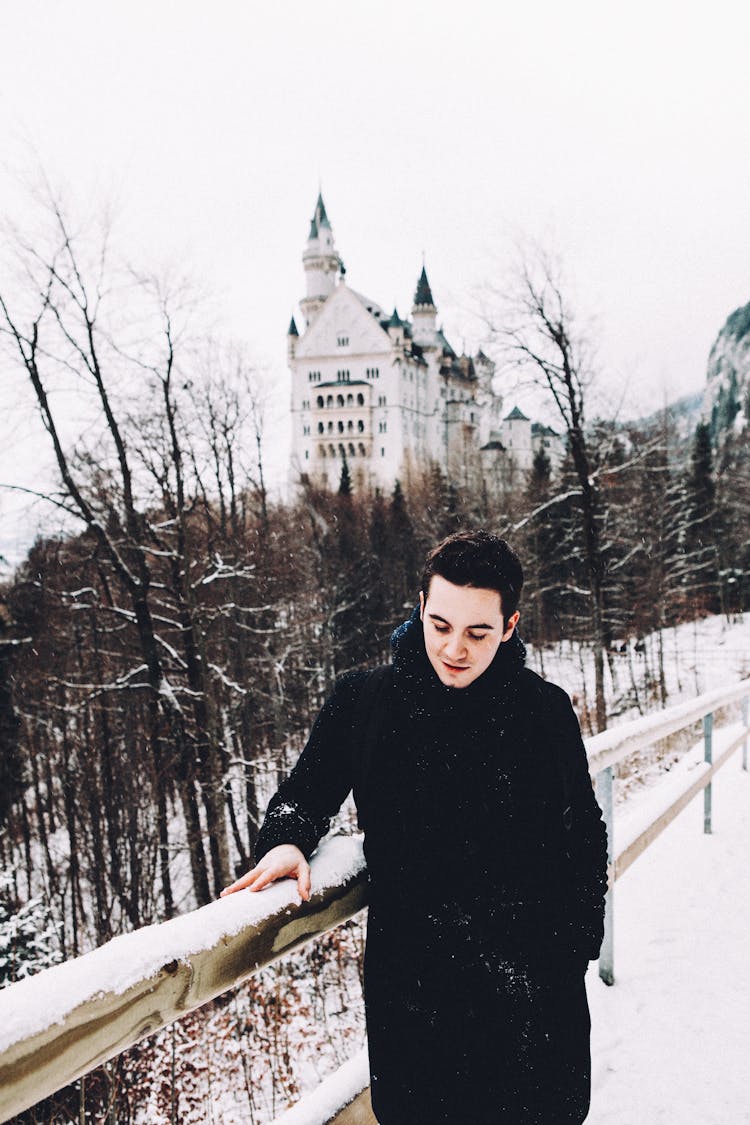 Smiling Man Touching A Railing In Snow