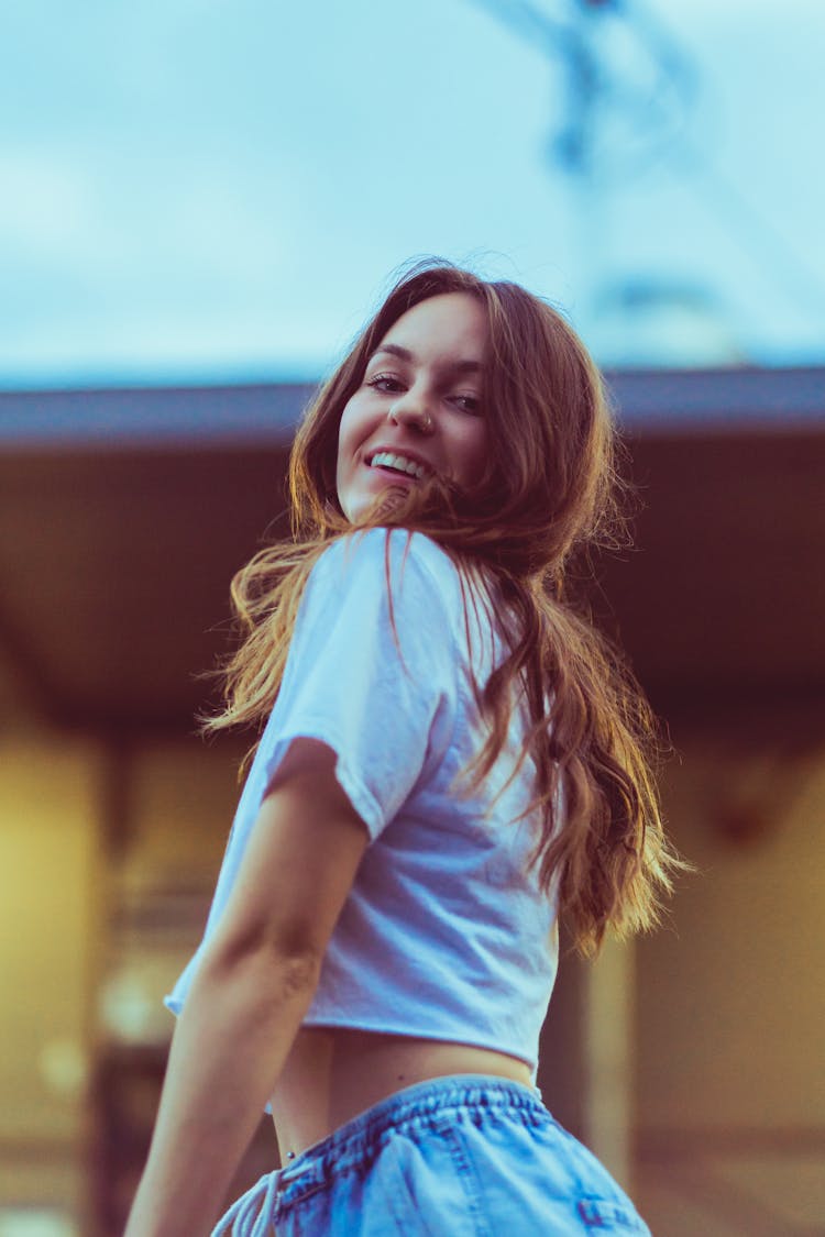 Young Smiling Woman With Long Brown Hair Posing Outdoors