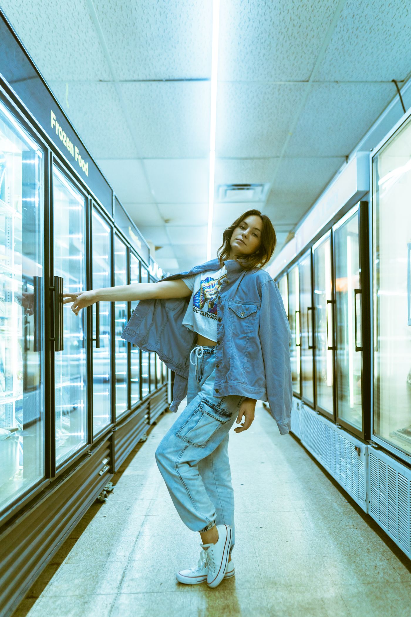 Fashion model in a denim outfit posing in a retail setting