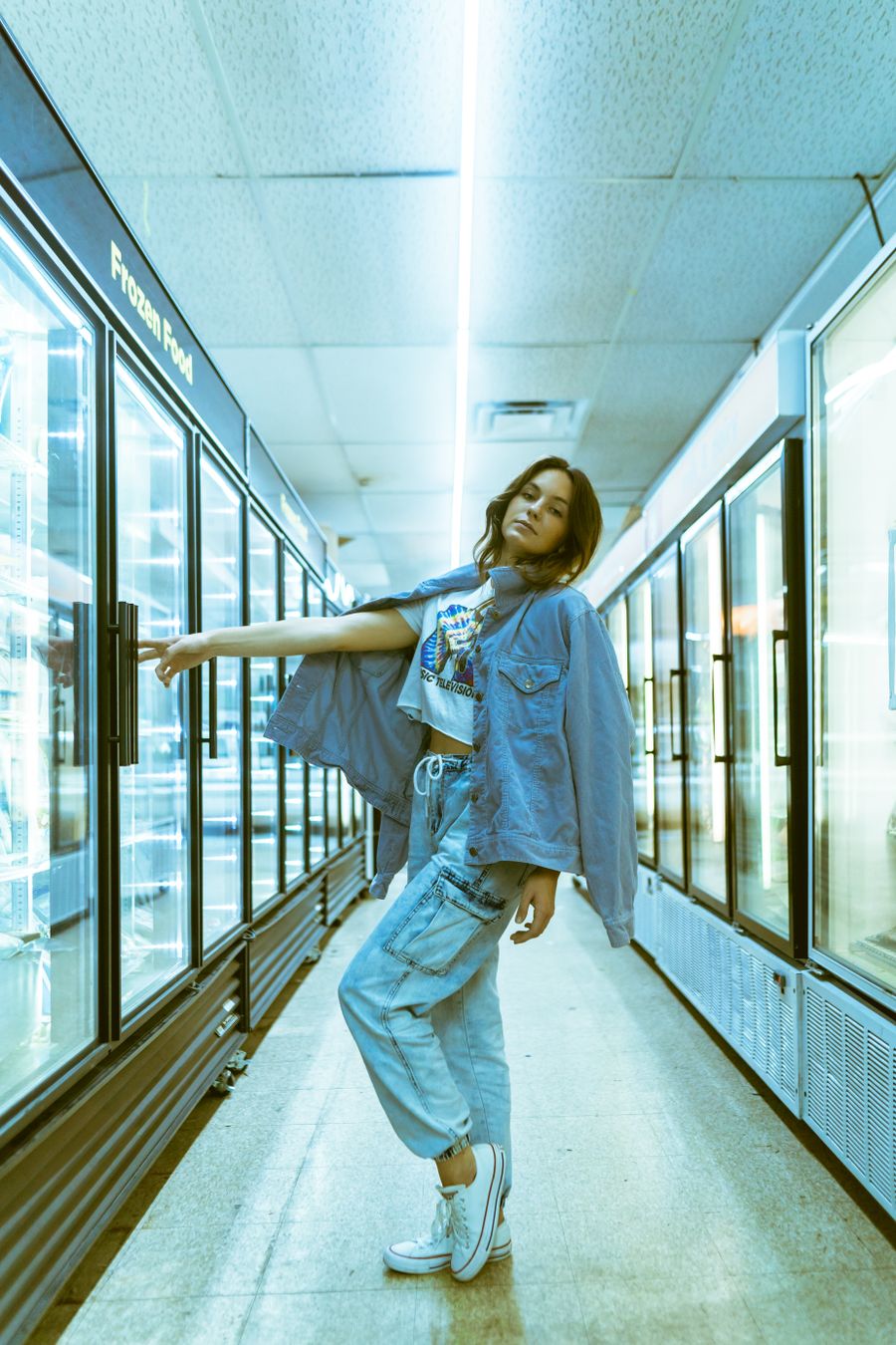 Fashion model in a denim outfit posing in a retail setting