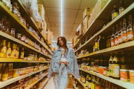 Girl in Denim Jacket and Jeans Walking Along Shop Shelves