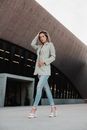 Woman in White Coat Standing Near Brown Concrete Building