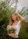 Woman in White Tank Top Holding White Flower