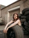 Woman in White Tube Dress Sitting on Black Car Tire