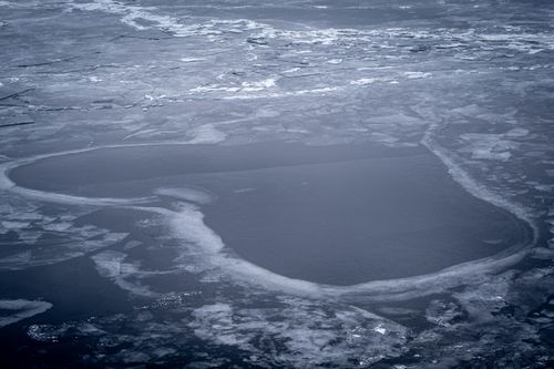 Free Aerial view of a frozen sea with intricate frost patterns and ice formations. Stock Photo