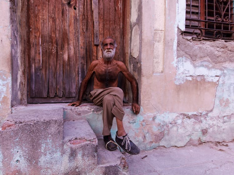 Shirtless Man Sitting On A Threshold